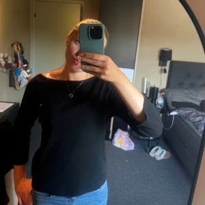 Svart topp från Napapijri - Svart topp från Polo Jeans Co  med liten broderad logga på bröstet. Modellen har trekvartsärm och en klassisk, något bredare rund halsringning. Skön och stilren, passar perfekt till jeans eller kjol.