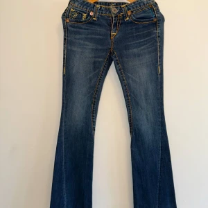 True Religion - Säljer ett par äkta True Religion jeans. Snygga bakfickor med klassiska True Religion detaljer. Jeansen är i fint sick och passar både till vardags eller för att klä upp med en festtopp!!💕 {Längd: 102cm, Innerbenslängd:80cm}.