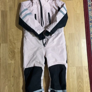 Rosa/svart vinteroverall  - Knappt använd, värmer ordentligt.