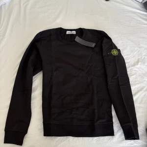 Svart sweatshirt från Stone Island - Säljer en svart sweatshirt från Stone Island . Har 3 stycken av samma sort, storlekar L, XL och XXL. Nya och aldrig använda