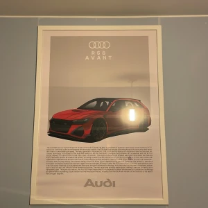 Audi RS6 Avant affisch - Snygg affisch med en illustration av en röd Audi RS6 Avant. Postern har en modern design med text om bilmodellen och Audi-logga upptill och nedtill. Perfekt för bilentusiasten eller som dekoration i hemmet. Super fint skick! Affischen från merchsweden, ramen från ikea
