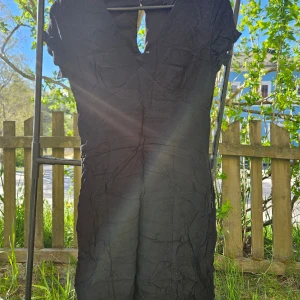 Svart kortklänning med v-ringning - Säljer en svart kortklänning med v-ringad hals och korta ärmar. Klänningen har en figurnära passform och är perfekt för dig som gillar en enkel men stilren look. Passar till många olika tillfällen.