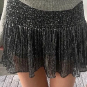 Glittrig svart volangkjol från Zara - Supersnygg festkjol från Zara med glittrigt tyg och smockad midja. aldrig använd💓 första bilden är lånad🫶🏻 PRIS KAN DISKUTERAS