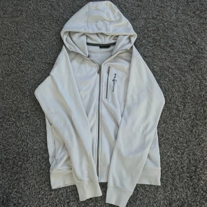 Vit hoodie från Sail Racing - Vit hoodie från Sail Racing i storlek M. Hoodien är i använt skick. Skriv mid minsta fundering.