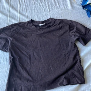 Mörkbrun croppad t-shirt - En basic mörkbrun t-shirt i croppad modell med rund halsringning. Tillverkad i 100% bomull för en skön och mjuk känsla. Perfekt till jeans eller shorts för en avslappnad look. Det är en lite tjockare variant av en t-shirt💗