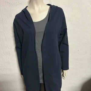 Mörkblå hoodiejacka med huva och vintage-tryck onesize - Helt ny öppen HUVJACKA i mörkblått. Storlek onesize. Material i skön bomull. Dragsko nertill. Onesize, men lite rymlig.