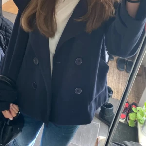 Design by si kappa - Säljer en mörkblå design by si kappa, Jackan har långa ärmar med knappdetalj vid ärmslut och två framfickor. Perfekt för dig som vill ha en klassisk och stilren look. Den är lite nopprig därav priset.