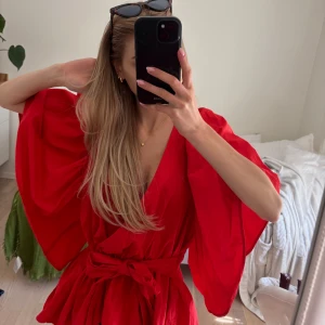 Röd omlottblus med volangärmar - Säljer en röd omlottblus med breda volangärmar och knyt i midjan. I fint skicklig från Zara, storlek M men passar även S