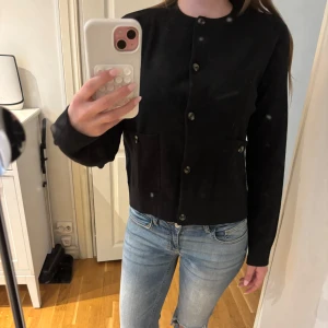 Svart kofta från Zara - Säljer en svart kofta från Zara med knappar framtill. Jackan har två fickor med knappdetaljer och är långärmad.