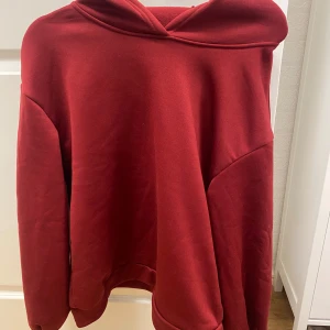 Mörkröd hoodie - Säljer en enkel och stilren mörkröd mysig  hoodie med luva. Tröjan har långa ärmar och en klassisk passform, perfekt för en avslappnad look. Inga synliga loggor eller mönster. Osäker på storleken då det inte står men passar not allt från xxs-m