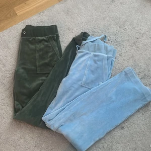 Juicy Couture mjukisbyxor i grönt och ljusblått - Två par klassiska Juicy Couture mjukisbyxor, ett par i mörkgrönt och ett par i ljusblått. Säljer då dom inte kommer till användning. Den gröna har inga snören. Bägge tillsammans går för 750 kr. 