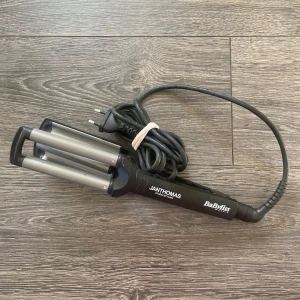 BaByliss Jan Thomas Studio Styling vågtång - En svart vågtång från BaByliss i samarbete med Jan Thomas Studio Styling. Tången har tre cylindriska värmeplattor i silverfärgat metallmaterial och ett ergonomiskt handtag!💞💞