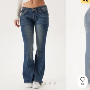 Blå bootcut jeans från True Religion - Snygga blå jeans från True Religion med bootcut-passform och klassiska gula sömmar. Jeansen har låg midja, fem fickor och dekorativ knapp på bakfickan. Perfekta för dig som gillar en tidlös jeanslook. Använda typ 5 gånger 