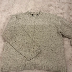 Ljusgrå stickad kofta från bikbok - Mysig ljusgrå stickad kofta från bikbok med diskret melerat mönster. Koftan har lång ärm, rund halsringning och ribbade muddar vid ärmslut och nederkant. Perfekt för lager-på-lager under kyliga dagar.