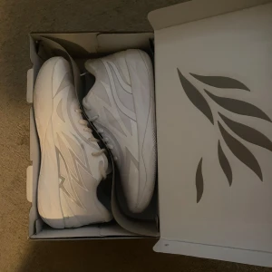 Puma MB.02 Lo vita Basketskor - 44.5 EU - Säljer ett par fräscha Puma MB.02 Lo basketskor i helvitt med silvriga detaljer. Använda ett fåtal gånger (3ggr).