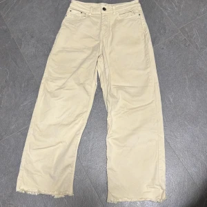 Beiga wide jeans från JDY W34 L32 - Snygga beiga jeans från JDY i modell med breda ben och råa, fransiga benslut. Klassisk femficksdesign och normal midja. Perfekta för en avslappnad och trendig look.