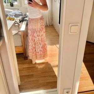 Mönstrad långkjol - Sååå såå fin långkjol i rosa/oreanga toner. Den går hela vägen ned till golvet för mig som är 167cm. Den är i onesize men har ett strechigt resorband i midjan. Nyskick. Köpt för 599 kr💗🫶🏻