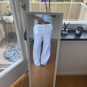 Vita broderade linnebyxor med snörning - Säljer ett par vita linnebyxor med broderade blommor och snörning i midjan från Gina Tricot. Byxorna har en loose och wide passform. Aldrig använda som nya. Stl M