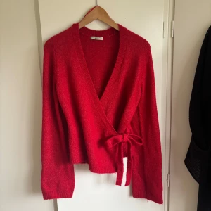 Röd omlottkofta med knyt - Röd omlottkofta från Gina tricot, använd på julafton och inget mer. 