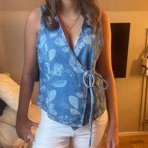 Blommig omlott jeanstopp - Säljer denna snygga blå blommiga toppen! Helt ny!! LAPP KVAR!!  Perfekt till vita jeans eller kjol för en fräsch sommarstil.