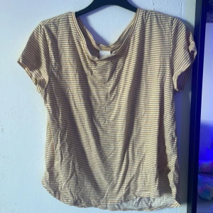 Beige och vit randig t-shirt H&M - Randig t-shirt från H&M i beige och vitt. Klassisk rund halsringning och korta ärmar. Tunt och mjukt material, perfekt för varma dagar. Enkel och stilren design som funkar till allt.