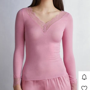 Rosa intimissimi tröja med spetsdetaljer - Supersöt rosa intimissimi tröja med v-ringning och spetsdetaljer vid halsringning och ärmslut. Mjuk och stretchigt material. 