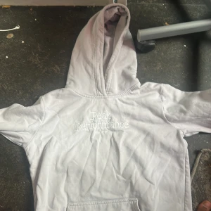 Ljusgrå hoodie Peak Performance - Säljer en ljusgrå hoodie från Peak Performance med broderad logga på bröstet. Klassisk modell med huva och känguruficka framtill. Perfekt för chill dagar eller när du vill ha en clean och enkel stil.