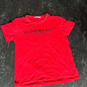Givenchy t-shirt - Snygg röd t-shirt från Givenchy med svart logotyptryck på bröstet. Klassisk rund halsringning och korta ärmar. Perfekt för dig som vill ha en statement-tee med lyxig känsla. Materialet är mjuk bomull som känns skönt mot huden. S och M 