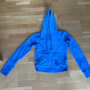 Blå velour hoodie Juicy Couture XS - Juicy Couture hoodie i klarblå velour med dragkedja och huva. Några smuts fläckar har den men det är inget man tänker på. Nypris 1000-1300 fick den i present så är inte säker. säljer den för jag inte andvänder den längre och den börjar bli för liten.