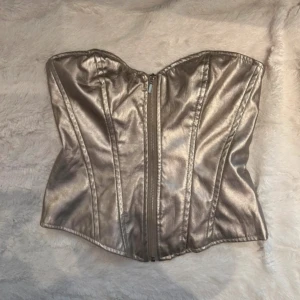 Guldig korsett tröja  - Snyggaste fest toppen med dragkedja framtill. Storlek L men liten i strlken så passar mig med M 💕🩷 aldrig använd