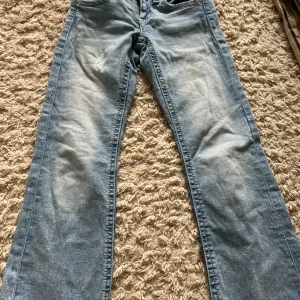 Ljusblå bootcut jeans Gina Tricot - Säljer ett par ljusblå bootcut jeans från Gina Tricot i storlek 152. Jeansen har klassisk femficksdesign, snyggt slitna detaljer och är tillverkade i mjukt bomullsjeans. Perfekta för dig som gillar en avslappnad och trendig look.