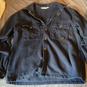 Mörkblå overshirt från H&M - Snygg mörkblå overshirt från H&M med klassisk krage. Perfekt att ha på hösten och våren!