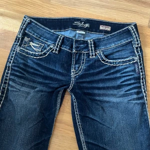 Jättecoola mörkblå Lågmidjade jeans - Säljer dessa som tyvärr är för långa på mig, innerbenslängden är 82 cm och midjemåttet rakt över är 36 cm💕!