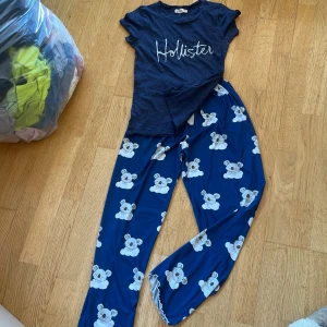 Ett fint pyjamas sätt - Supersköna blå mjukisbyxor med gulligt koalamönster över hela byxan. Byxorna har resår i midjan och vid bensluten, vilket gör dem extra bekväma. Materialet är mjukt och stretchigt, tillverkat av 95% polyester och 5% elastan. Perfekta för chill hemma eller sleepover. Tröjan är i XS. Gjort av ett mjukt material passar perfekt till byxorna 