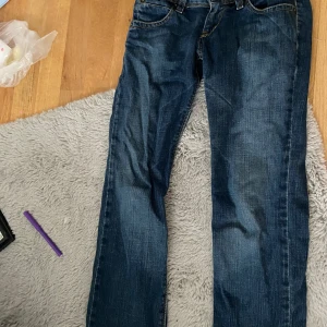 Levi's 570 Straight Fit jeans blå - Säljer ett par Levi's 570 Straight Fit jeans i klassisk mörkblå tvätt. Modellen har raka ben, fem fickor och kontrastsömmar. Jeansen är tillverkade i slitstarkt denim och har en snygg, tidlös look som funkar till det mesta.skriv om ni har funderingar! Säljer för dom är lite små.