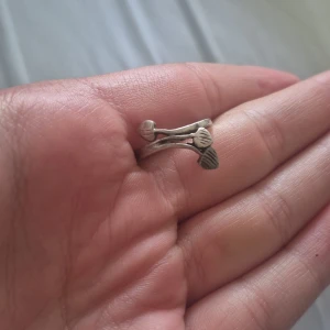 Söt silverring med bladmotiv - Unik silverring i 925 sterling med två tunna band som möts i små bladformade detaljer. Ringen har en cool, organisk design som sticker ut och passar perfekt för dig som gillar naturinspirerade smycken. Enkel men ändå speciell, perfekt att bära varje dag.
