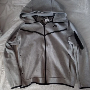 Grå nike tech - Säljer en grå nike tech(helt ny). Endast använd fåtal gånger och inga tecken på det! Bara att höra av sig vid någon fundering!