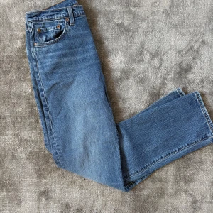 Levi's 501 blå jeans straight fit - Klassiska Levi's 501 jeans i blå denim med straight fit. Snygga kontrastsömmar, fem fickor och ikonisk läderpatch baktill. Perfekta för dig som gillar tidlös stil och vill ha ett par jeans som alltid funkar. Levi's-röd etikett på bakfickan. Dom är aldrig använda men prislappen är av. Tveka inte på att höra av dig vid frågor och funderingar!!