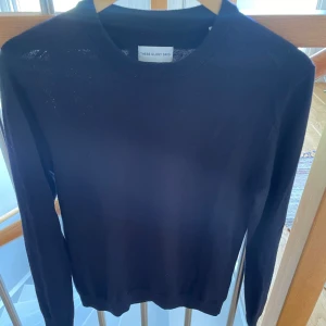 Mörkblå stickad tröja These Glory Days - Snygg mörkblå stickad tröja från These Glory Days i storlek M. Tröjan har rund hals och långa ärmar, perfekt för dig som gillar stilrena och klassiska plagg. Materialet är mjukt och skönt, passar till jeans eller chinos.