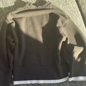 Svart stickad tröja med ribbad kant - Svart stickad tröja med ribbad kant i nederdelen och vid ärmsluten. Från Gina tricot. Vid snabb affär kan pris diskuteras 