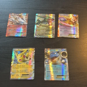 Pokémon EX Holo Collection - Samling av fem glittrande Pokémon EX-kort: Pikachu, Blastoise, Reshiram, Rayquaza och Mewtwo. Perfekt för dig som älskar Pokémon och vill ha coola, sällsynta kort att visa upp eller spela med. Färgstarka motiv och holografisk finish gör dem extra attraktiva för samlare och fans.