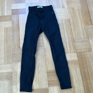 Svarta skinny jeans från Gina Tricot - Säljer ett par svarta Molly Perfect Jeans från Gina Tricot i storlek S. Modellen är högmidjad med skinny passform och klassisk femficksdesign. Jeansen har dragkedja och knapp framtill, och är gjorda i stretchigt bomullsmaterial för en bekväm känsla.