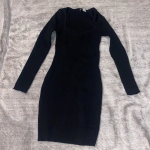 Svart ribbad klänning från H&M - Snygg svart ribbad klänning från H&M Divided med lång ärm och v-ringad hals. Materialet är mjukt och stretchigt, vilket gör den superbekväm att bära. Aldrig använd endast provat💞💖💖💖
