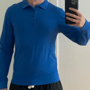 Pikétröja  - Blå pikétröja. Storlek XS