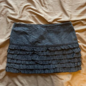 Blå volangkjol från Hilfiger Denim - Supersöt blå lågmidjad kort- jeanskjol från Hilfiger Denim. 