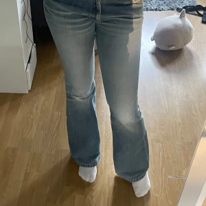 Bootcut jeans från Lee,  - Säljer ett par snygga bootcut jeans från Lee i ljusblå tvätt. De har klassiska fickor, Lee-logga på bakfickan och läderpatch i midjan. Jeansen är tillverkade i slitstarkt bomullsmaterial. Perfekt för dig som gillar retrovibbar och bekväm passform. Lite sönder mellan benen men man ser inte igenom och det syns inte när dom är på!💞