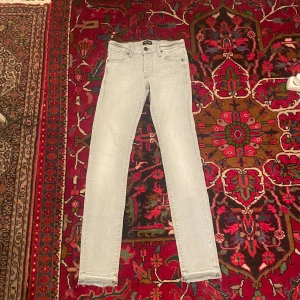 Ljusgrå slim jeans Jack & Jones - Snygga ljusgrå slim fit jeans från Jack & Jones, modell Glenn. Klassisk femficksdesign, smal passform och tillverkade i mjukt denimtyg. Perfekta för dig som gillar en stilren och modern look.