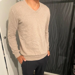 John Henric tröja beige - Snygg beige v-ringad tröja från John Henric i storlek Medium.  Väldigt fin i skick och utseende och perfekt nu till hösten😁