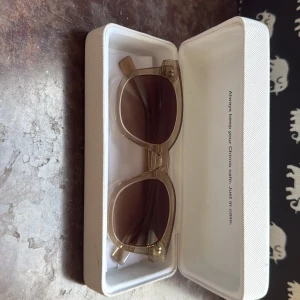 Beige solglasögon från CHIMI - Snygga solglasögon från CHIMI med transparent beige båge och bruna glas. Modellen 02 och kommer i originalfodral. Perfekt accessoar för att lyfta din stil under soliga dagar.