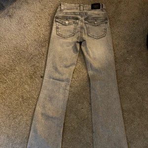 Gråa lågmidjade bootcut jeans från Gina  - Jeansen är storlek 32. Dom är bara använda några få gånger 